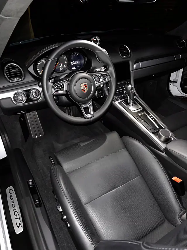 Porsche 718 Cayman GTS seats and carpet at night, freshly detailed.