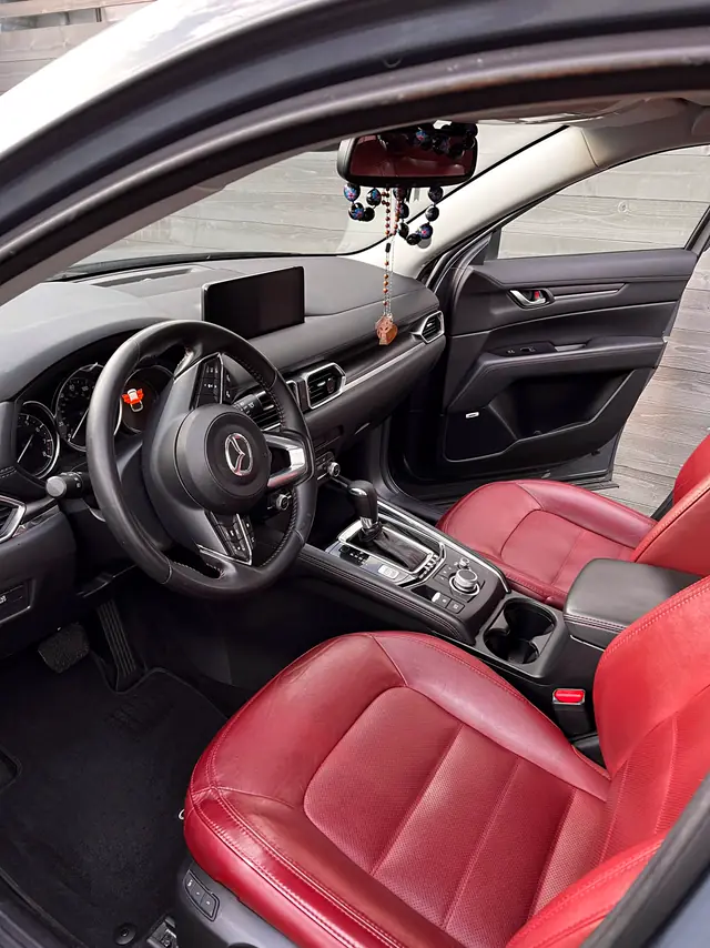 Mazda CX-5 front cabin after: clean red leather and mats.