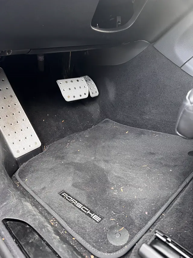 Porsche Macan GTS driver footwell before: dusty mat with debris.