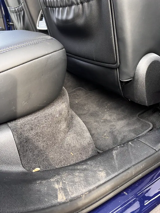 Porsche Macan GTS rear floor before: dirty mat and scuffed sill.
